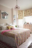 Romantic bedroom with patterned throw on bed