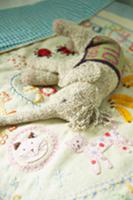 Soft toy on embroidered child's bedspread