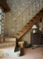 Wooden staircase against stone wall in a rustico