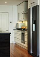 Corner of designer kitchen with white cupboard doo