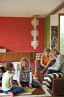 Children playing on rug and sofa in living room