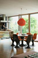 Brown plastic shell chairs with orange cushions in