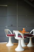 Dining area with white shell chairs and red cushio