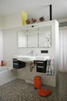 Sink and mirror on white tiled partition in bathro