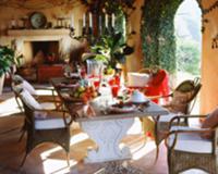 A hammock hangs across the loggia with oak chairs 