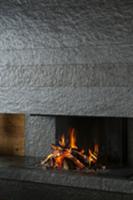 Blazing fire in open fireplace clad in dark grey s