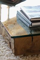 Stack of books on low table made of glass top on w