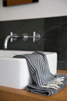 Small towels in shades of grey on wooden washstand