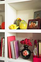 White book shelves with vase of roses, yellow glas