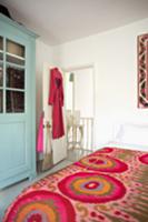 Feminine bedroom with a jazzy, colorful bedspread,