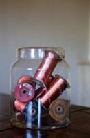 Old spools of thread in storage jar