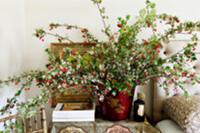 Twigs with berries on bedside table in bedroom