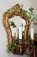 Antique, wall-mounted mirror with candle lamp