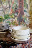 Stacked ceramic bowls in front of painting