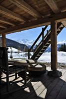 Seating area on terrace of wooden hut in snowy mou