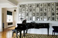 Concert grand piano against wall with gallery of p