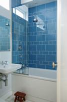 Corner of bathroom with bathtub and shower head ag