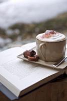 A cappuccino with pralines on a saucer sitting on 