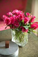 Bouquet of pink roses in glass vase and ceramic bo