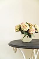 Bouquet of roses in glass vase on vintage table