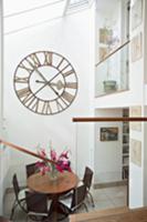 View of dining area beneath antique wall clock in 