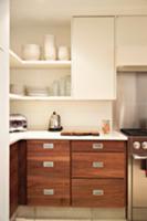 Corner of kitchen with crockery on shelving above 