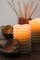 Wooden spoon and lit candles in front of bowl of j