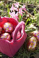 Chocolate Easter eggs in a pink felt basket in a m