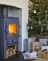 Gifts below Christmas tree next to cast iron log b