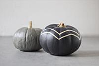 Pumpkins painted grey, one with zig-zag pattern