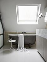 Free-standing bathtub under sloping skylight and a