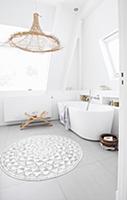 Free-standing bathtub and wicker lamp in bright ba