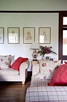 Red and floral cushions on checked sofas in living