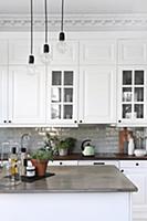 Pendant lamps above island counter in white countr