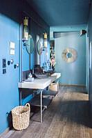 Washstand with twin sinks against blue wall in hal