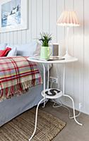 Lamp on delicate table next to bed in bedroom