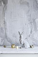 Easter bunny and eggs against grey rendered wall