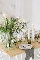 Table set for wedding with vase of tulips, dry twi