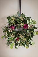 Handmade Christmas wreath with roses on wall