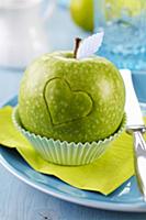 Green apple carved with love heart in cake case on