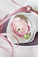 Pink ranunculus wrapped in linen napkin tied with 