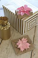 Pink paper flowers decorating wrapped gifts