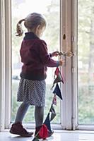 Girl hanging bunting in window