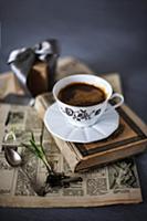 Old newspaper, book, cup of coffee and flower