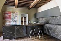 Black marble panels and rustic beams in modern kit