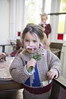 Girl wearing knitted sweater smelling posy