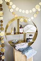 Golden garland above round shelving unit containin