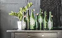 Arrangement of green glass bottles painted with ma