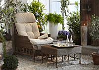 Wicker chair in pleasant seating area amongst lush