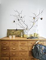 Gold-painted glass bottles on wooden chest of draw